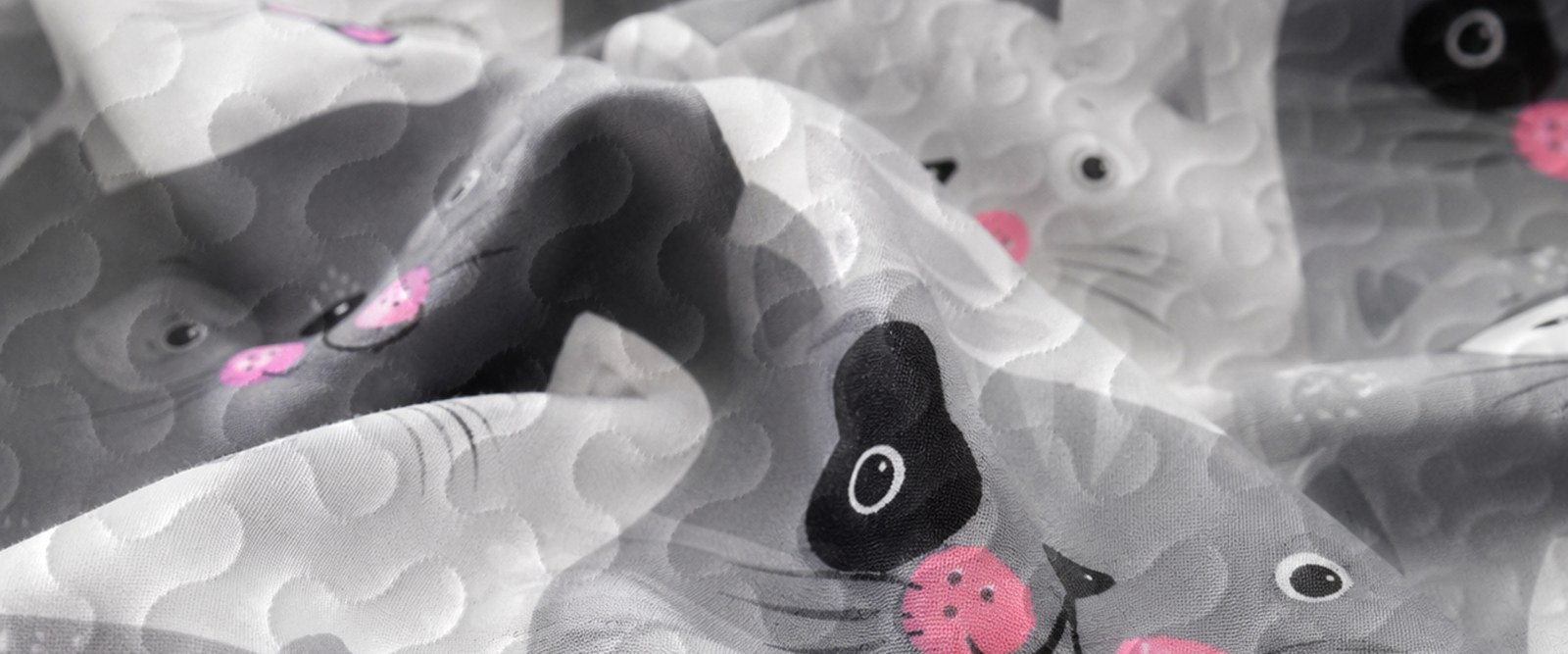 Macro close-up of soft microfiber quilted fabric texture with detailed cat print